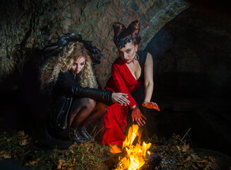 Naklejka premium Witches conjure by the fire on Halloween night. Ghost girls.