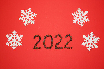 Cristmas figures 2022 with coffee on red background. Christmas number 2022. Christmas figures 2022 with snowflakes. Christmas background.