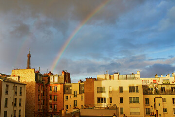 Scenic view of the Eiffel tower with rainbow over the roofs of residential buildings in Paris