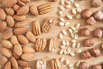 Many different nuts. Assortment healthy snacks. Mediterranean diet. Dry vegan charcuterie. Variety party pile. Kitchen table. Fat nutrients. Almonds, pecans, pine, hazelnuts,