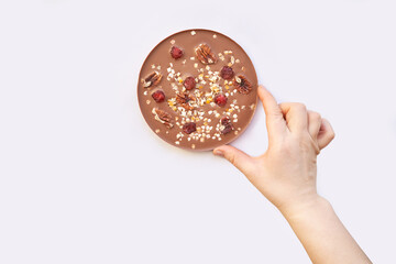 Hand made swiss milk chocolate. Christmas brown textured bar. Top view. Pecan, cranberry, nuts. Handcrafted dessert. Sweet christmas food. Sugar and cacao candy gift