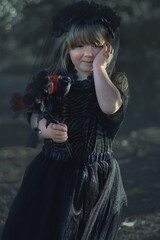 Upset child in a black dress and a black veil