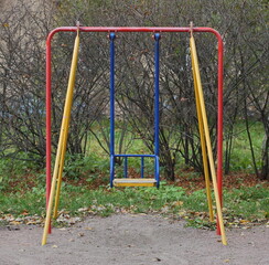 Colorful children's swing on the playground in autumn