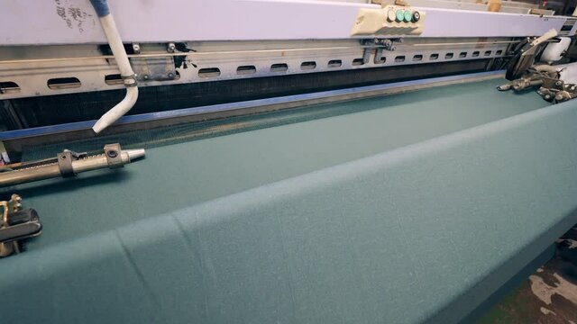 Woven fabric is getting released by an industrial machine