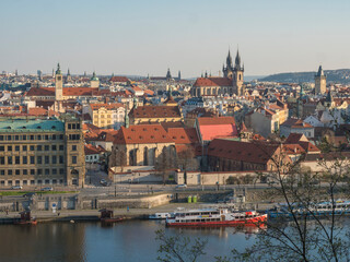 Scenic aerial view of Prague Old Town architecture roof top over Vltava river with houseboat seen from Letna hill park, spring sunny day, blue sky, Czech Republic