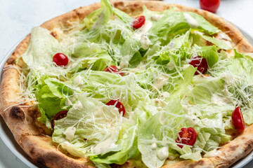 pizza Caesar with chicken, parmesan, egg, cherry tomatoes and fresh lettuce, top view