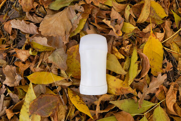 Mock up a bottle of deodorant on yellow autumn maple leaves background