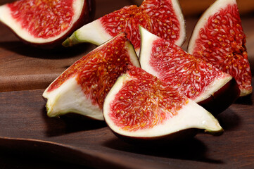 A few figs on a wooden background. Ripe delicious fresh figs. Sliced figs on a wooden plate.  Selective focus