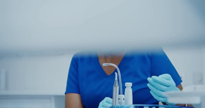 A nurse takes saliva ejector and inserts it into the mouth of a patient