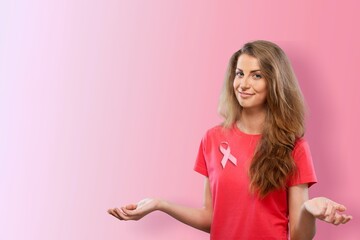 A woman in T-shirt with a pink satin ribbon symbolizing International Breast Cancer Day,