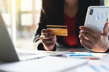 Business man holding credit card and using mobile phone. Check credit card limit via mobile internet. Conduct online financial transactions concept. Online shopping.