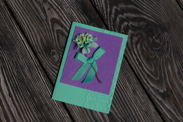Handmade postcards. With decorative elements in the form of flowers and ribbons. Against the background of pine boards.