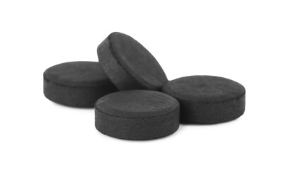 Activated charcoal pills on white background. Potent sorbent