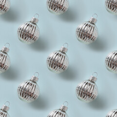 Seamless pattern of Christmas shiny silver baubles on blue background. Xmas abstract background.