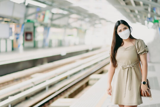 Asian woman wearing protection face mask at Railroad Station Platform,commuter and transportation concept