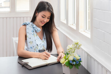 Young asian woman in smart casual wear working in home office. Social distance practice prevent coronavirus COVID-19.