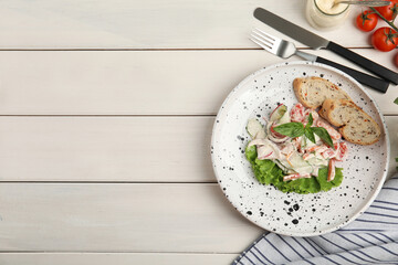 Plate of delicious vegetable salad dressed with mayonnaise and croutons served on white wooden...
