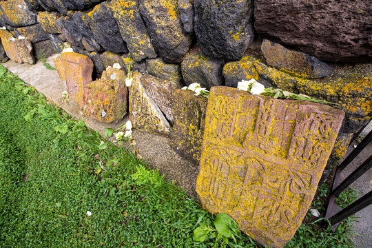 traditional Armenian carved khachkar or cross-stone with flowers installed near Sevanavank monastery. Remembrance and memorial ceremony