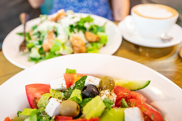 Greek salad with feta cheese and olives on a plate in a cafe as a symbol of Mediterranean cuisine and diet