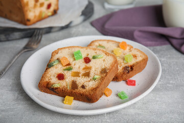 Delicious cake with candied fruits on light grey table