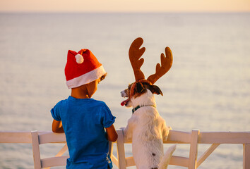 Calm and happy Christmas at seashore concept. Two friends in Christmas hats looking at seascape....