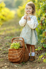 Beautiful little girl with grapes. Child with fruit. High quality photo