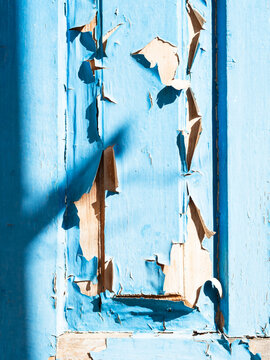 part of aold wooden door with peeling blue paint
