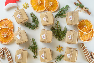 Advent calendar for waiting for Christmas and New Year among dried oranges, gingerbread cookies and fir twigs. Eco-friendly packaging, zero waste