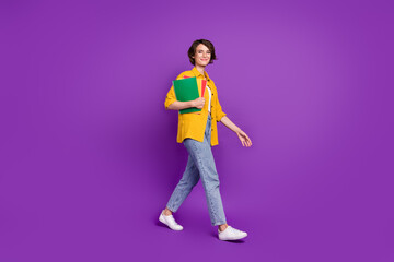 Full length body size view of attractive cheery girl holding materials going college isolated over bright violet purple color background