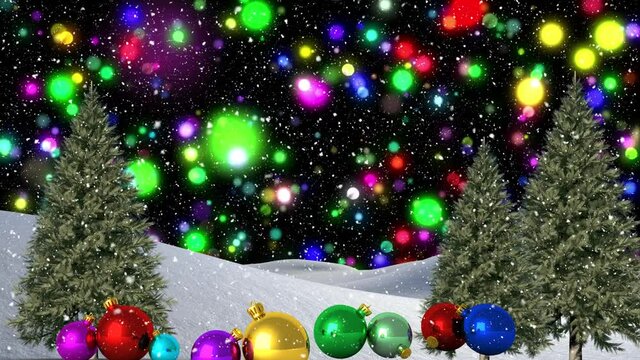 Colorful blue light spots and snow falling over colorful christmas baubles on winter landscape
