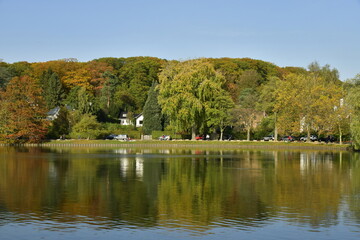 Le lac de Genval dans un cadre bucolique avec ses villas et immeubles à appartements dissimulés dans la nature luxuriante qui l'entoure en automne