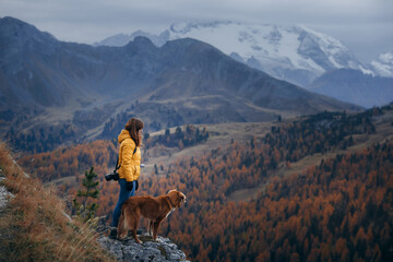young woman with a dog at the top, peak. travel Nova Scotia Duck Tolling Retriever 