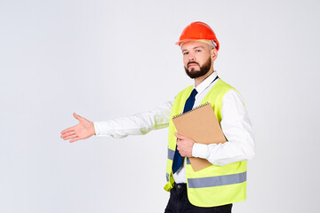 Cheerful construction worker in reflective vest and helmet holding blueprints.
