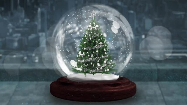 Blue shooting star spinning around christmas tree in a snow globe on wooden surface