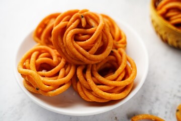 Homemade Murukku Chakli or Thenkuzhal - Navratri Diwali snacks isolated, selective focus