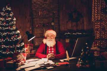 Photo of aged santa claus happy positive smile sit desk north pole christmas decoration eve time...