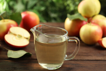 Natural apple vinegar and fresh fruits on wooden table