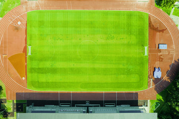 Aerial view of green football field. New public soccer stadium empty to be used for soccer game outdoors from above. Beautiful soccer playground as background texture concept