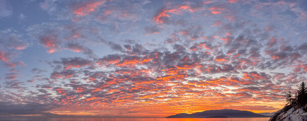 Fototapeta na wymiar Panoramic View of colorful cloudscape during dramatic sunset on the ocean coast. Taken in Vancouver, British Columbia, Canada. Nature Panorama