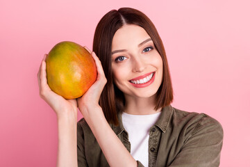 Photo of cool brunette hairdo young lady hold mango wear green shirt isolated on pink color background