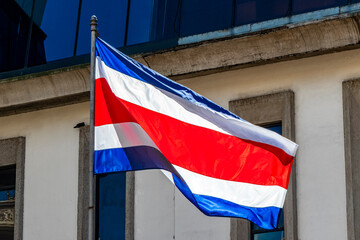 Flag of Costa Rica old buildings behind Costa Rican flag.