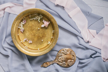 vintage copper basin bowl pan of water with fresh flowers, antique mirror, silk ribbons, personal care,  luxury spa, top view from above, nobody