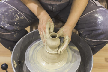 Ceramic Artist hands mold clay on pottery wheel. Arts creative workshop.