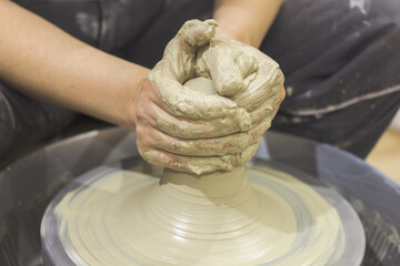 Ceramic Artist hands mold clay on pottery wheel. Arts creative workshop.