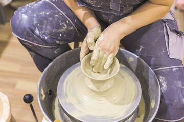 Ceramic Artist hands mold clay on pottery wheel. Arts creative workshop.