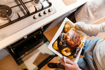 White couple cooking turkey for thanksgiving dinner with their friends