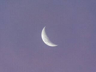 Obraz na płótnie Canvas Waxing crescent moon picture with a soft purple sky in the background.