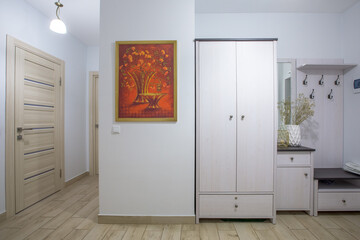 The interior of the corridor in a two-room apartment with a kitchen, in light colors