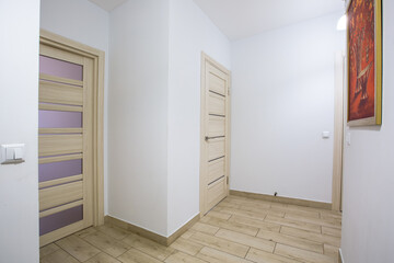 The interior of the corridor in a two-room apartment with a kitchen, in light colors