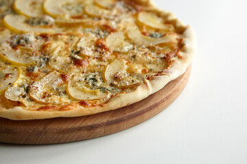 Pizza with cheese and pear fruit on cutting board